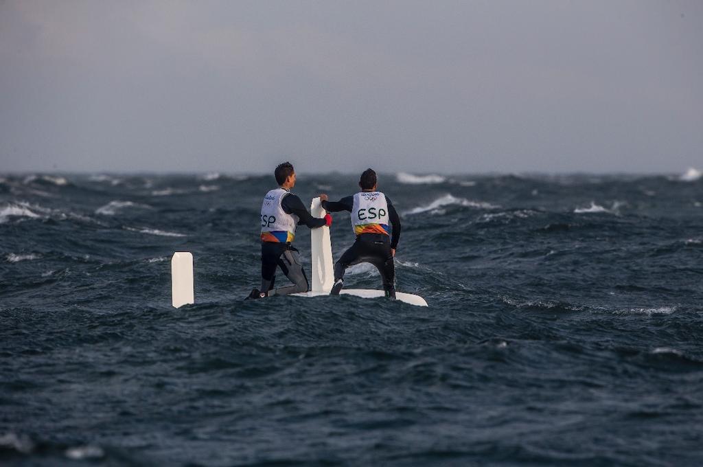 A Spanish 470 crew adopts the usual storm practice of upturning the boat and waiting for the squall to blow through - Day 8, 2016 Olympic Regatta © Sailing Energy / World Sailing